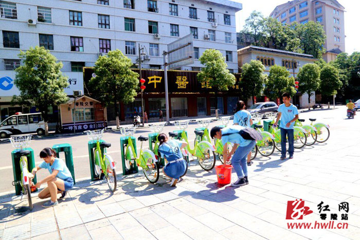 大學(xué)生志愿者清洗災(zāi)后公共自行車